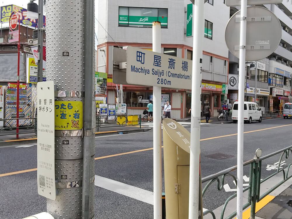 交番と地下鉄千代田線の1番出口を通り過ぎると、横断歩道横に表示があります